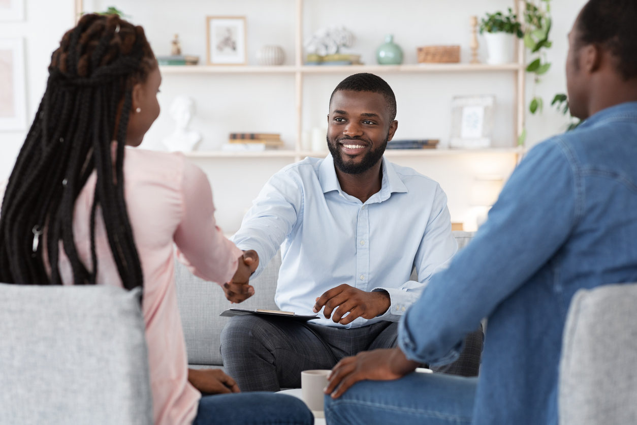 Family Counselor Shaking Hands With Happy Black Couple After Successful Therapy