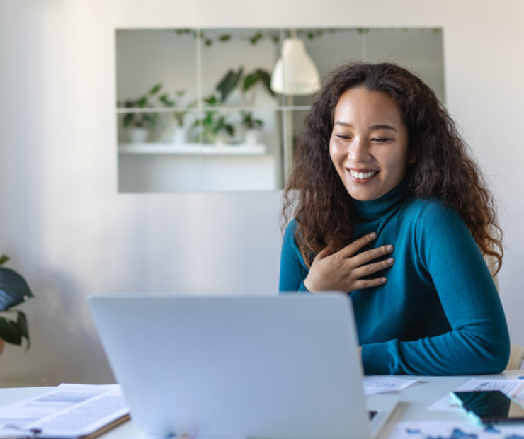 Asian businesswoman on a video call while sitting at her desk. Shot of an attractive young woman using her laptop to make a video call at home